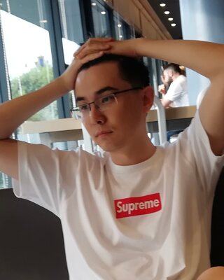 Weber Wang in a café, hands on his head, deep in thought